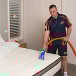 Technician performing a Deluxe Mattress Clean.
